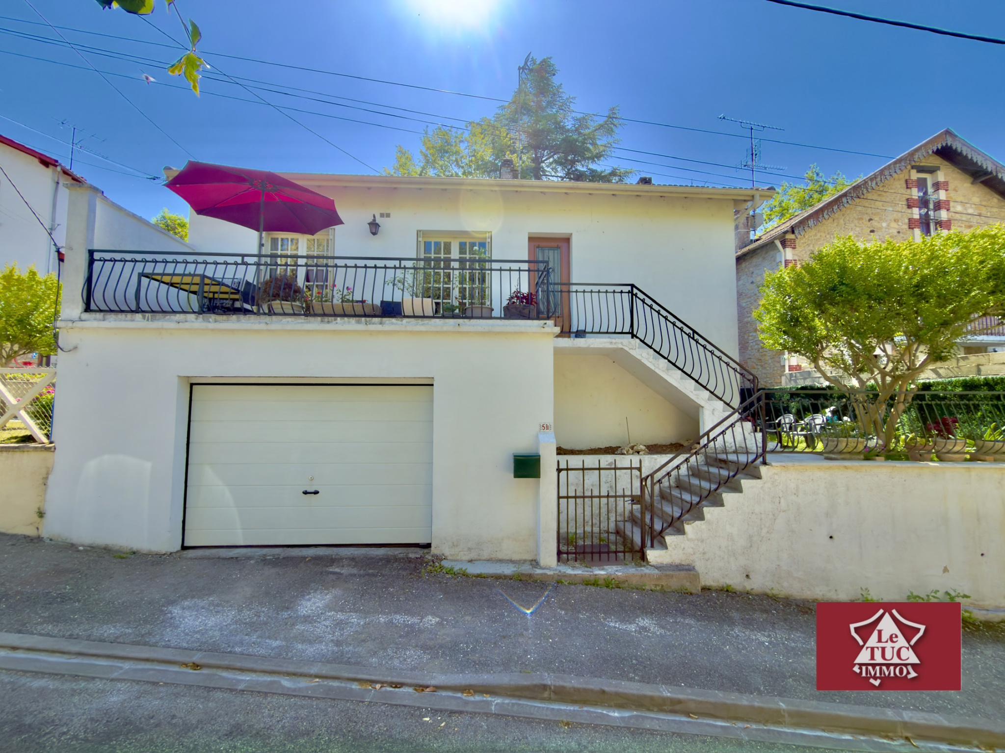 Maison avec grand garage, terrasses et jardin.